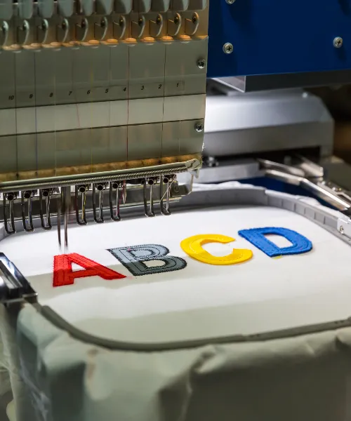 Detalle de bordado profesional en uniformes corporativos con logotipo